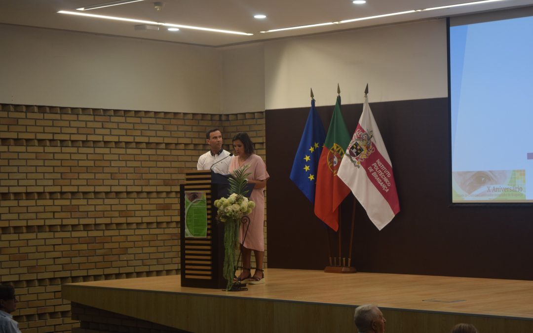 Imagem de um auditório com os apresentadores, um homem e uma mulher, do congresso no púlpito a apresentar o respetivo congresso.