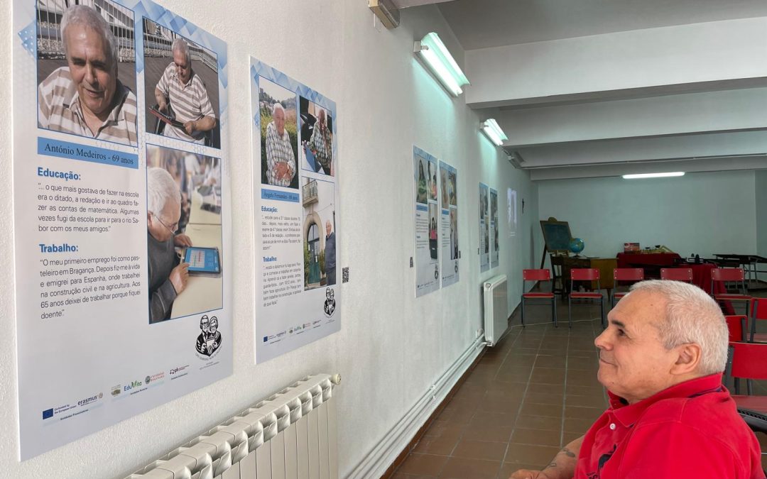 Utente homem da Unidade de Cuidados Continuados Integrados de Bragança, no museu etnográfico da Santa Casa, a contemplar o seu cartaz com fotografias e textos dele transcritos de uma entrevista que lhe foi feita com frases respeitantes à sua educação e ao seu trabalho.